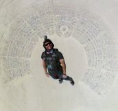 Fantastic shot of man skydiving into Burning Man…