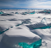 Due to a natural phenomenon, temperature, wind and sun cause the ice crust to crack and form beautiful turquoise blocks or ice hummocks on the surface of Lake Baikal in Siberia.
