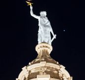 Blood moon supported by the Goddess of Liberty.