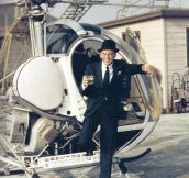 Frank Sinatra stepping off of a helicopter with a drink in his hand, by Yul Brynner, 1964.