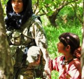A Curious Afghan Girl Holds The Hand Of An American Soldier