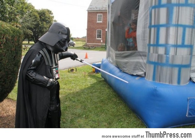 Darth Vader is frightening the kids in bouncing house.
