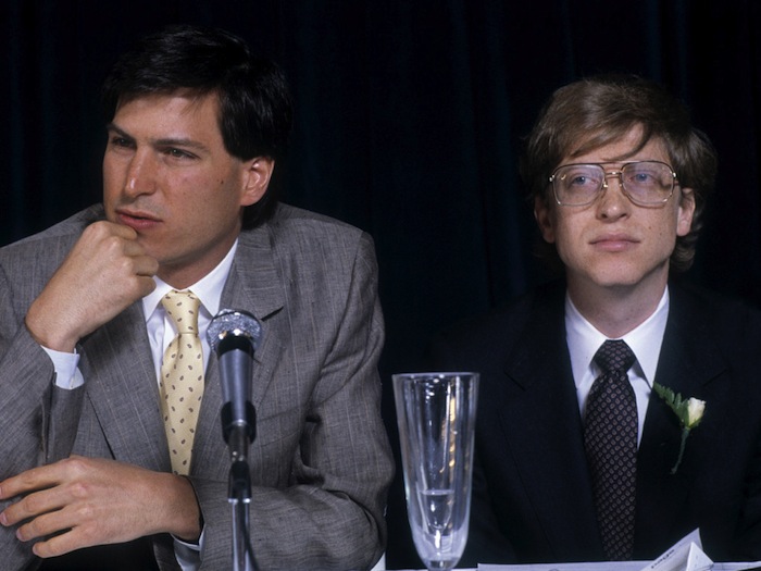 Steve Jobs of Apple answers a question while sitting next to Bill Gates of Microsoft at an interview in New York, 1984
