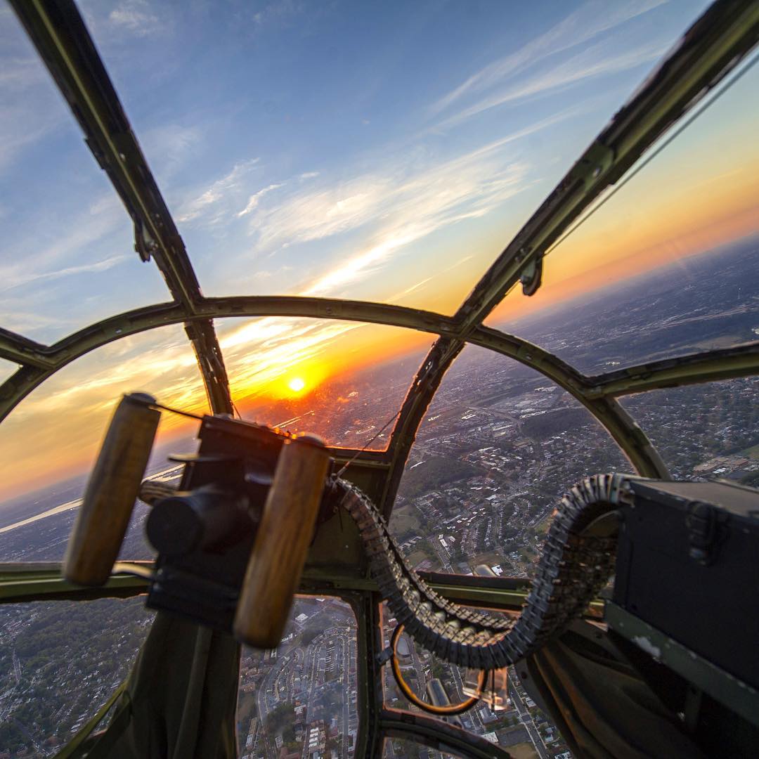 View of a sunset through the nose of an old B-25 bomber.