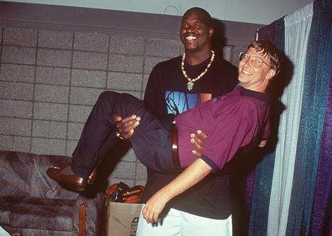 Shaquille O'neal holding $78 billion in small bills.
